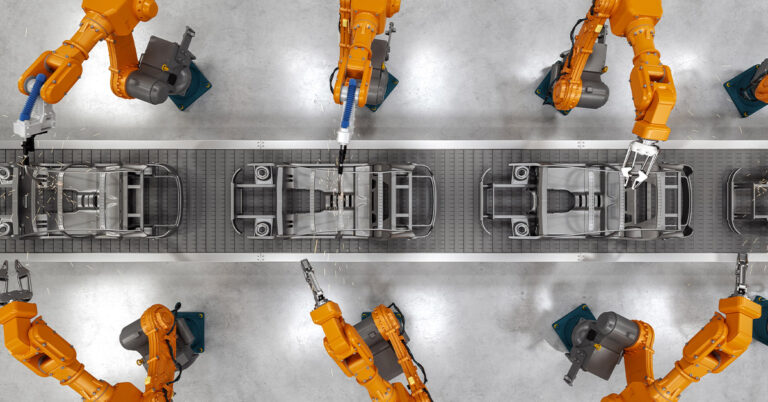 Top view of industrial welding robots at the automated car manufacturing factory assembly line.