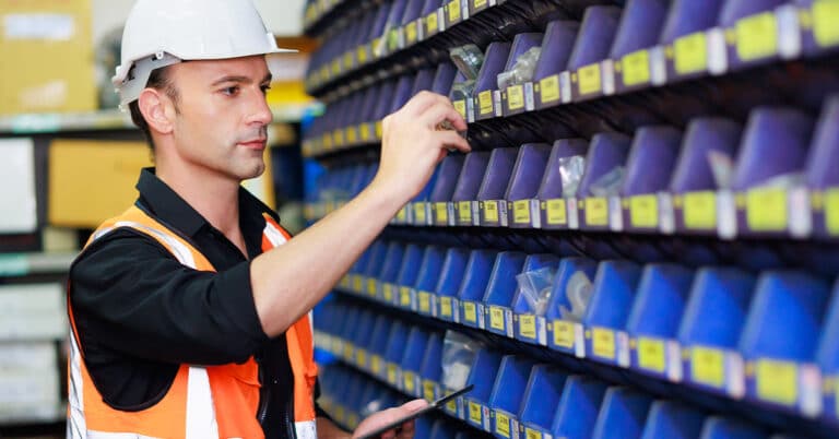 Male warehouse professional worker in safety vest and hardhat helmet in warehouse factory industrial.