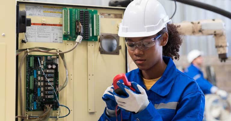 Woman electrician worker checking, repair, maintenance operation electric system in the factory production line.