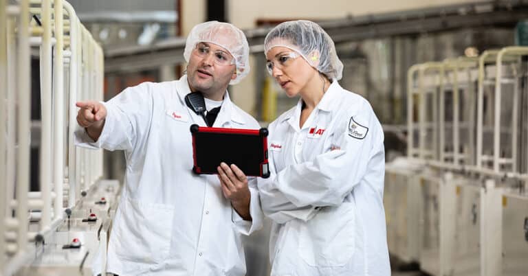 ATS employees using tablet device to observe production line.